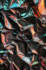 crumpled metallic foil with vibrant holographic reflections in abstract texture