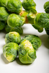 Fototapeta premium Green brussels sprouts on stalks on white table