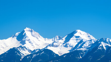 Obraz premium Snow-capped mountain peaks against a clear blue sky