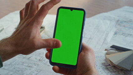 User hand zooming chroma key cellphone in creative office closeup. Unknown man