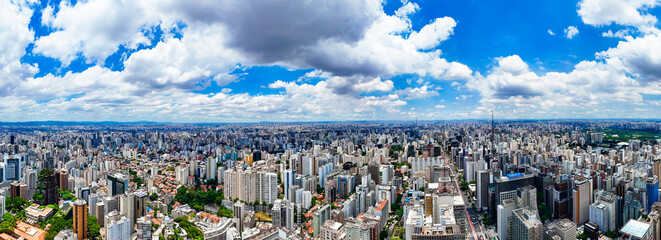 Visão aérea de 180 graus da cidade de São Paulo, destacando a vasta paisagem urbana, seus arranha-céus, avenidas e a agitação da metrópole, capturada em uma imagem panorâmica impressionante