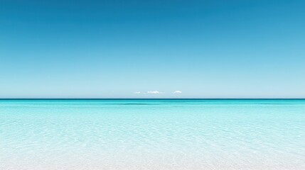 Calm, azure ocean meets a clear, cloudless sky. Tranquil, turquoise water, shallow, and serene.