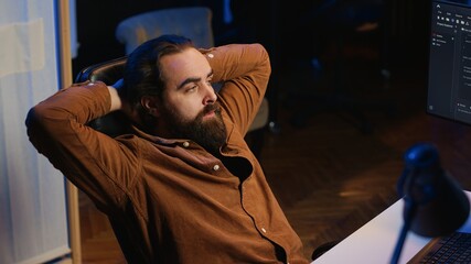 Annoyed software developer exasperated after failing to remove all bugs while coding on computer...