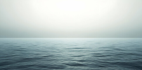 Obraz premium A serene view of calm ocean waters blending into a misty horizon.