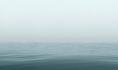 Obraz premium A serene view of calm water under a misty sky, evoking tranquility and peace.