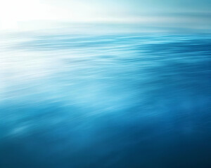 A serene blue abstract image depicting calm water with soft light reflections.