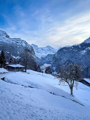 Scenic view of Lauterbrunnen Valley, Switzerland seen from Wengen with snowcovered Breithorn mountain in winter against blue sky with clouds