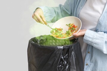 Young woman throwing spoiled food into trash bin on light background, closeup