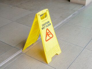 Yellow caution wet floor sign stands on the floor during maintenance, warning of slippery conditions. This safety sign helps prevent slips and falls during cleaning and purification activities
