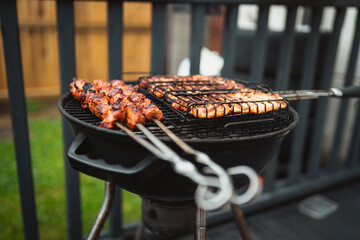 A sizzling barbecue grill loaded with juicy skewers of marinated meet and perfectly grilled sausages. the smoky aroma and golden char make it an irresistible treat for outdoor gatherings or summer par