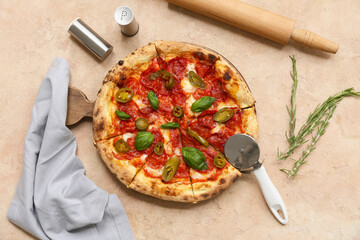 Composition with tasty pizza and cutter on beige background