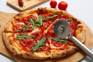Tasty pizza and cutter on grey background, closeup