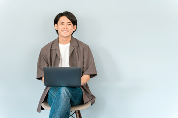 パソコンを使って副業・動画編集・ネットショッピングする若い男性
