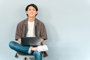 パソコンを使って副業・動画編集・ネットショッピングする若い男性
