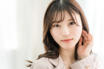 スーツを着て微笑む若いアジア人女性（ビジネスウーマン）
