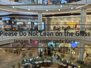 Obraz premium A sign asking people not to lean on the glass.