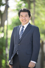 新緑の中事業承継や社長や経営者のカメラ目線イメージの縦
