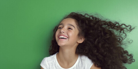 Fototapeta premium Joyful girl with curly hair laughs