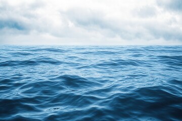 Fototapeta premium Calm ocean waves under a cloudy sky.