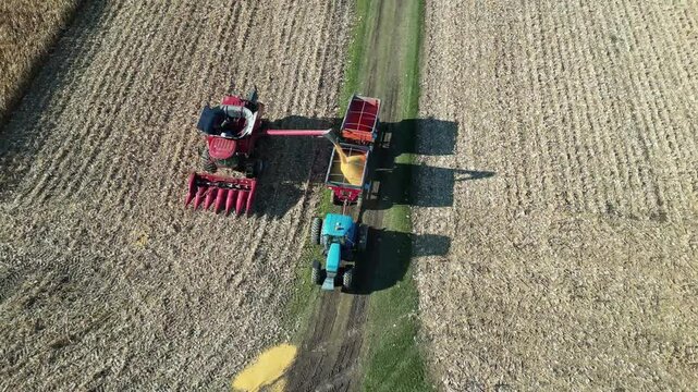 Top view by drone of a harvesting machine emptying corn into a tractor trailer - Vue de dessus par drone d'une machine agricole r&eacute;coltant vidant du ma&iuml;s dans la remorque d'un tracteur