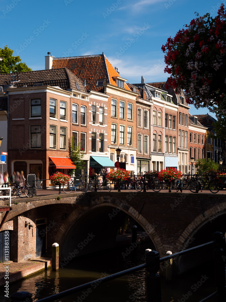 Wall mural City canal embankment of Utrecht, Netherlands. View of typical Dutch buildings and bridge across waterway.