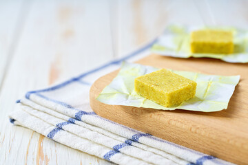 Two bouillon cubes set on a cutting board ready to be added to a pot of soup.