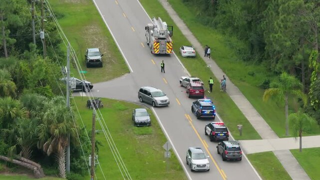 Top view of first responders at car accident site in Florida. Emergency services personnel helping victims of car crash on city street in USA.