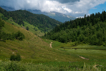 The valley of the Malaya Dukka River surrounded by the mountains of the North Caucasus and the tourist trail to the Dukka Lakes on a sunny summer day, Arkhyz, Karachay-Cherkessia, Russia © Ula Ulachka