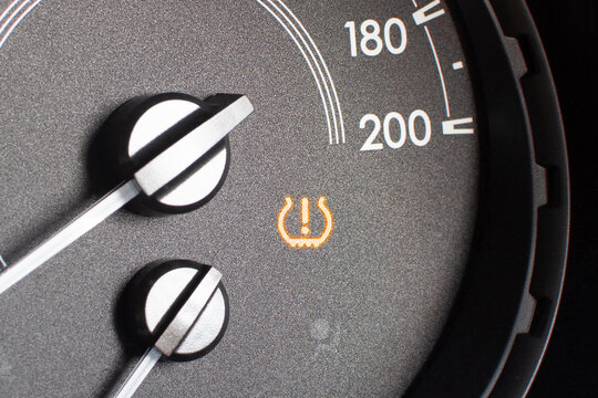 Tire pressure warning light on car dashboard , Automotive repair concept