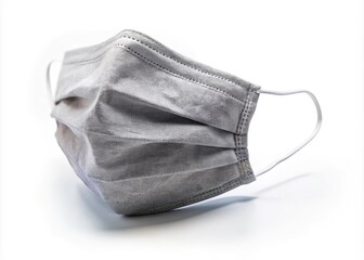 A solitary grey face mask dominates the frame, isolated against pure white.