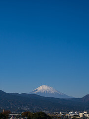 Fototapeta premium 富士山。東側。冬の晴天。山麓は、一度積もった雪が強風で吹き飛ばされた。 神奈川県小田原市内より。 Mt. East side. Clear winter sky. At the foot of the mountain, once accumulated snow was blown away by strong wind. Mt. Fuji. East side.