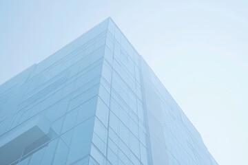Low-angle view of modern glass building against a clear sky.