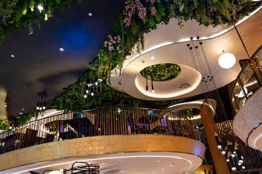 Modern restaurant interior featuring lush greenery and unique architectural design in a bustling city setting