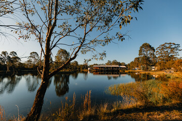 Obraz premium House nestled on small lake with reflection in afternoon sun