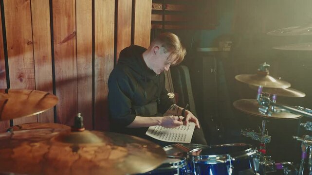 Musician practicing drumming techniques in a studio setting late at night