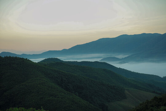 Panorama view layers of mountain with the fluffy white fog between the mountains and clear sky in background