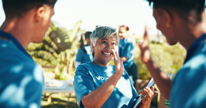 High five, volunteers and happy for charity, group and success of fundraiser, smile and mature woman. Outdoor, celebration and coordinator with good news for people, community service and nonprofit - Powered by Adobe
