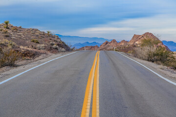 A long, empty road with a yellow line down the middle