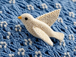 Obraz premium Knitted Bird on Blue Textured Fabric Handmade Crafts Cozy