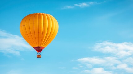 Fototapeta premium Yellow Hot Air Balloon Soaring in Blue Sky with Clouds