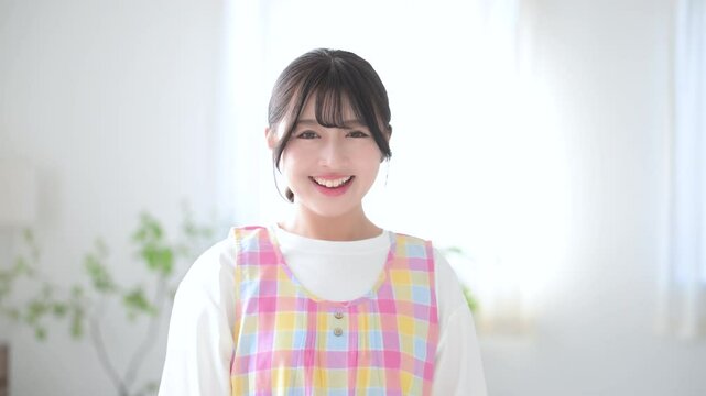 Image of smiling childcare workers, caregivers, babysitters, housekeepers, etc. waving bye-bye, changing jobs or jobs looking at the camera slow motion