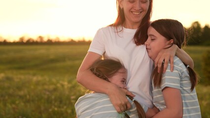 Obraz premium Family reunion field, Children running mom, Outdoor fun during sunset, Happy family moments, Summer evening joy, Kid mom embrace, Warm sunset nature, Family bonding time, Scenic outdoor playtime.