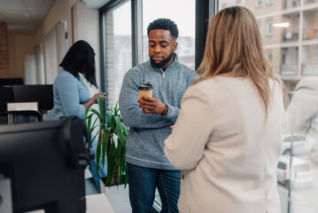Business people chatting by the window during coffee break