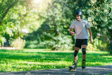 Fototapeta premium Young man rollerblading outdoors in a park, showcasing agility and fitness. The vibrant scene highlights an active lifestyle, enjoying exercise and recreation in a natural environment
