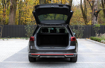 Huge empty trunk of a wagon black car in autumn. Open back door modern car. Car boot is open. Wagon clean trunk. Modern wagon car open trunk. Front view. © Best Auto Photo