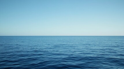 Obraz premium Ocean surface, clear sky, calm waters.