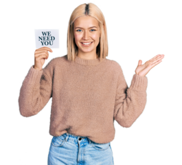 Beautiful young blonde woman holding we need a change banner celebrating victory with happy smile and winner expression with raised hands
