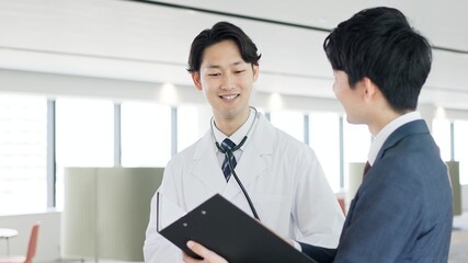 話をする医者と営業職の男性