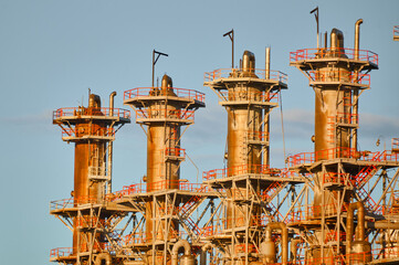 Distillation columns in a chemical plant against a clear sky illustrating industrial processes and...