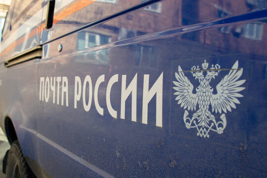 Artyom, Primorsky Krai, Russia - December 13, 2024: Inscription in Russian: Russian Post and the coat of arms of Russia on a blue background of the metal coating of the car